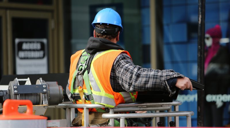 A man with hi-vis and helmet on a construction site