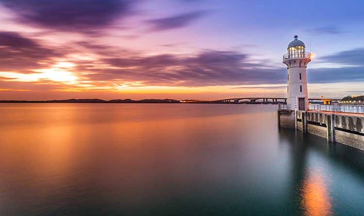 Lighthouse,During,A,Colorful,Sunset,Over,The,Malacca,Strait,Overlooking,the,water