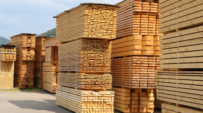 Image of piles of timber in a lumber yard surrounded by blue skies to support mass timber article