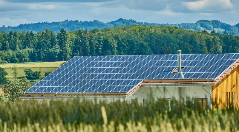 A house with a large array of solar panels on the roof, showcasing renewable energy use in sustainable building.