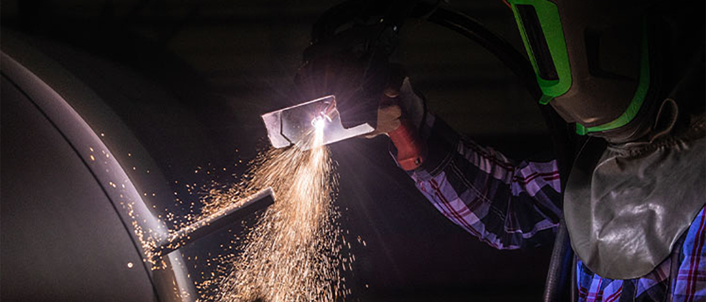 Construction worker in protective clothes working on equipment to support Apache Industrial  article