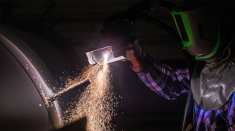 Construction worker in protective clothes working on equipment to support Apache Industrial  article