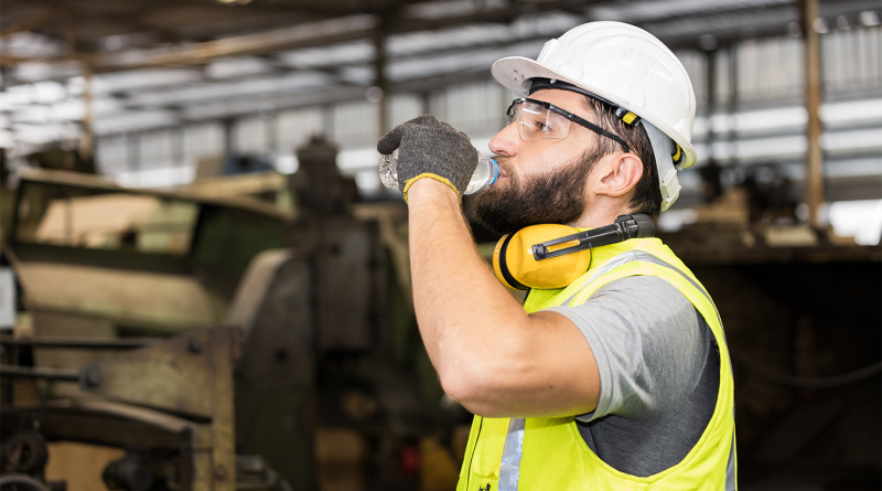 Construction worker drinking water and keeping hydrated to combat heat stress