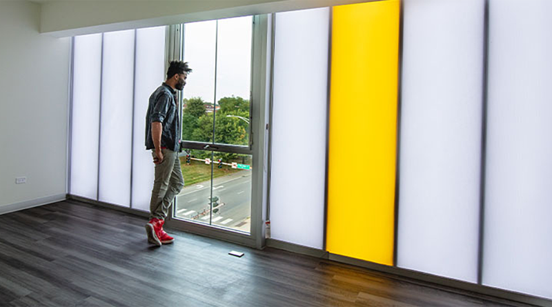 Man stood looking out window to support impacts of natural daylight on mental health article