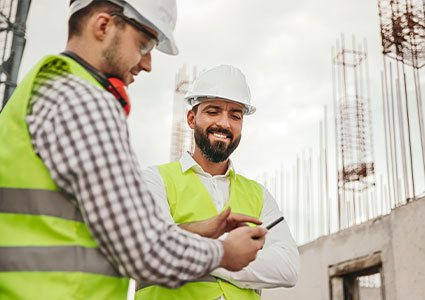 Construction workers on sitewearing PPE a white hard hat and high visibility jacket looking up their career in construction