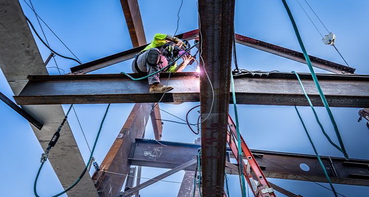 Welder welding steel beams on a roof