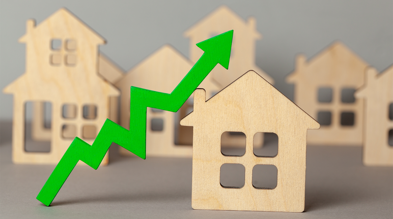 Wooden models of houses with green arrow pointing upwards to support steel and aluminum tariffs article