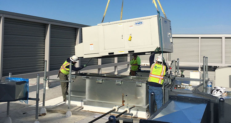 workers installing a commercial Rooftop Unit (RTU) HVAC system