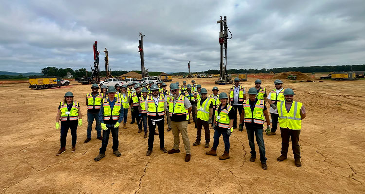 a construction site team posing for a group photograph at a large-scale project location.