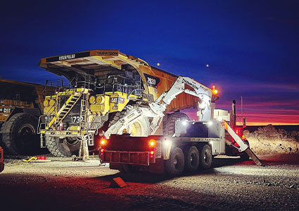 a massive mining dump truck during the night or twilight hours