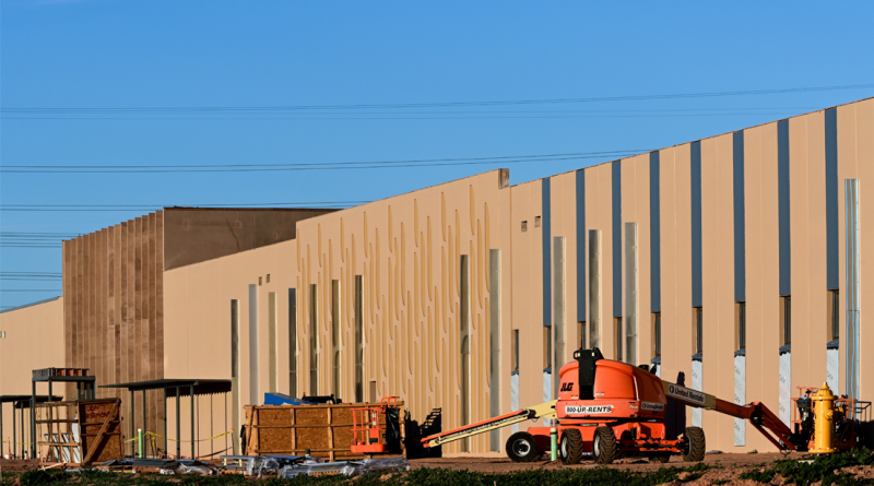 Large-scale data center under construction with prefabricated concrete panels and heavy equipment