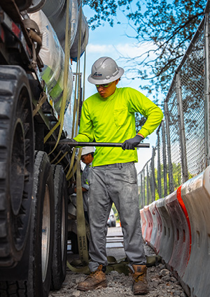 a construction worker securing a load on a commercial utility vehicle.