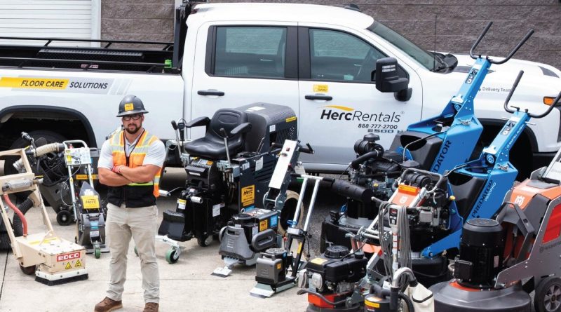 Worker with industrial floor care equipment beside a Herc Rentals truck.