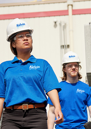 two people  wearing Kelvin Group branded blue shirts and white hard hats