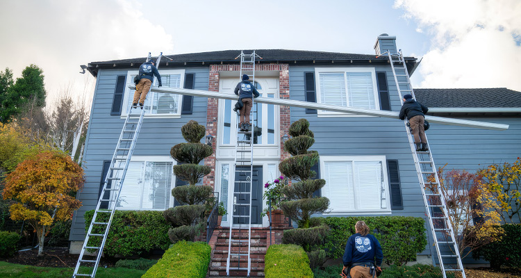 a specialized crew from The Brothers that just do Gutters performing work on a two-story residential home