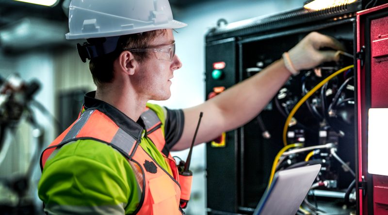Electrician installing infrastructure at a large-scale AI data center facility.