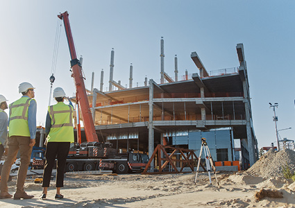 a commercial construction site where professionals are overseeing the erection of a multi-story building framework