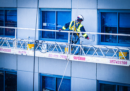 a single construction or maintenance worker on a motorized suspended scaffolding system