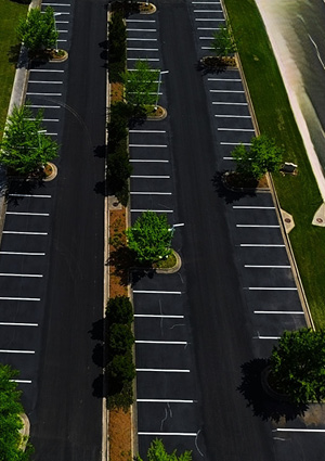 An aerial, high-angle view shows an organized, empty asphalt parking lot