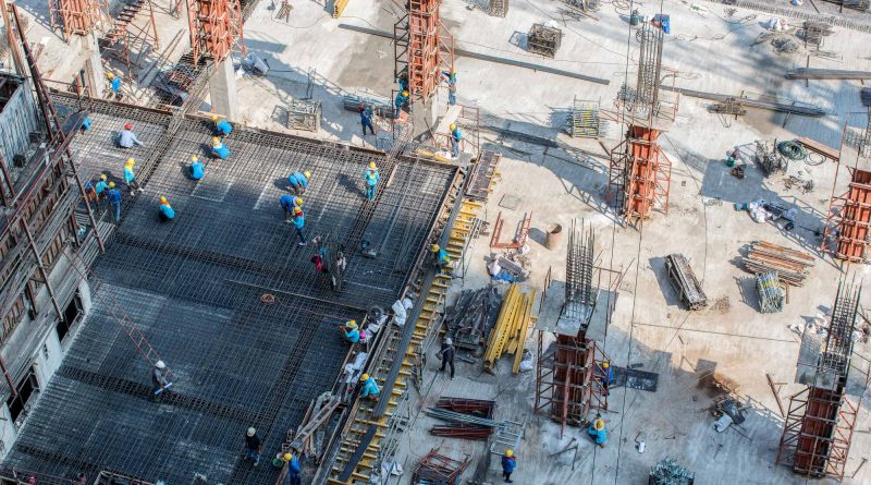 Construction workers on a commercial building site, illustrating rising construction costs, labor constraints and increased project demand in 2026.