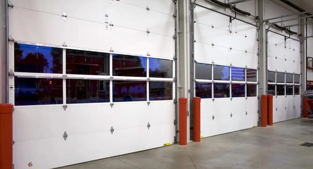 Interior view of commercial overhead doors with vision panels, showing heavy-duty construction suitable for high-traffic emergency service facilities.
