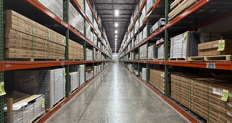 an industrial warehouse interior with orange and green heavy-duty pallet racking systems