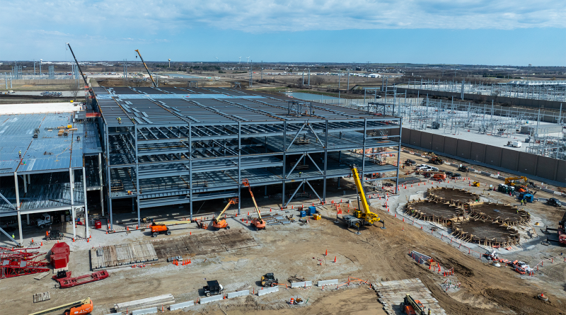 Construction continues on a Microsoft data center expansion, showing steel framework, cranes, and active development on site.