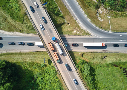 an aerial view of a highway overpass intersection with cars and trucks