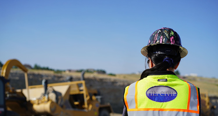 a worker wearing a safety vest and hard hat branded with HEI Civil