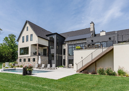 a modern luxury farmhouse with an in-ground swimming pool and patio area