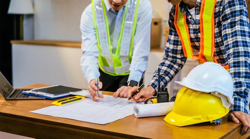 construction engineer and supervisor checking blueprint for heavy steel pipeline material inspection.